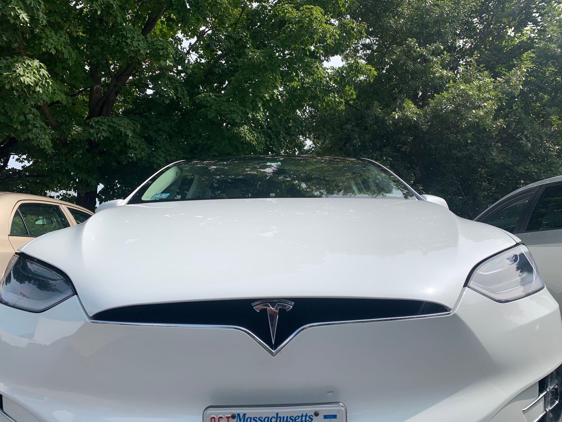 A white tesla model s is parked in a parking lot