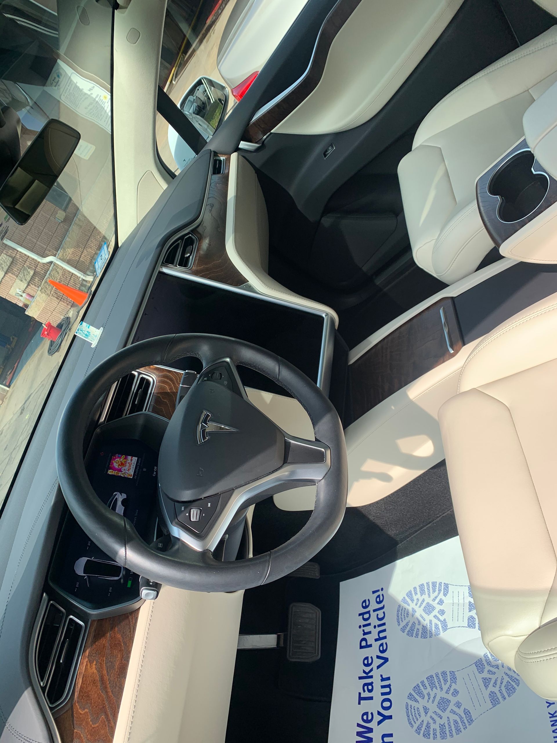 The inside of a tesla model s with a steering wheel and seats.