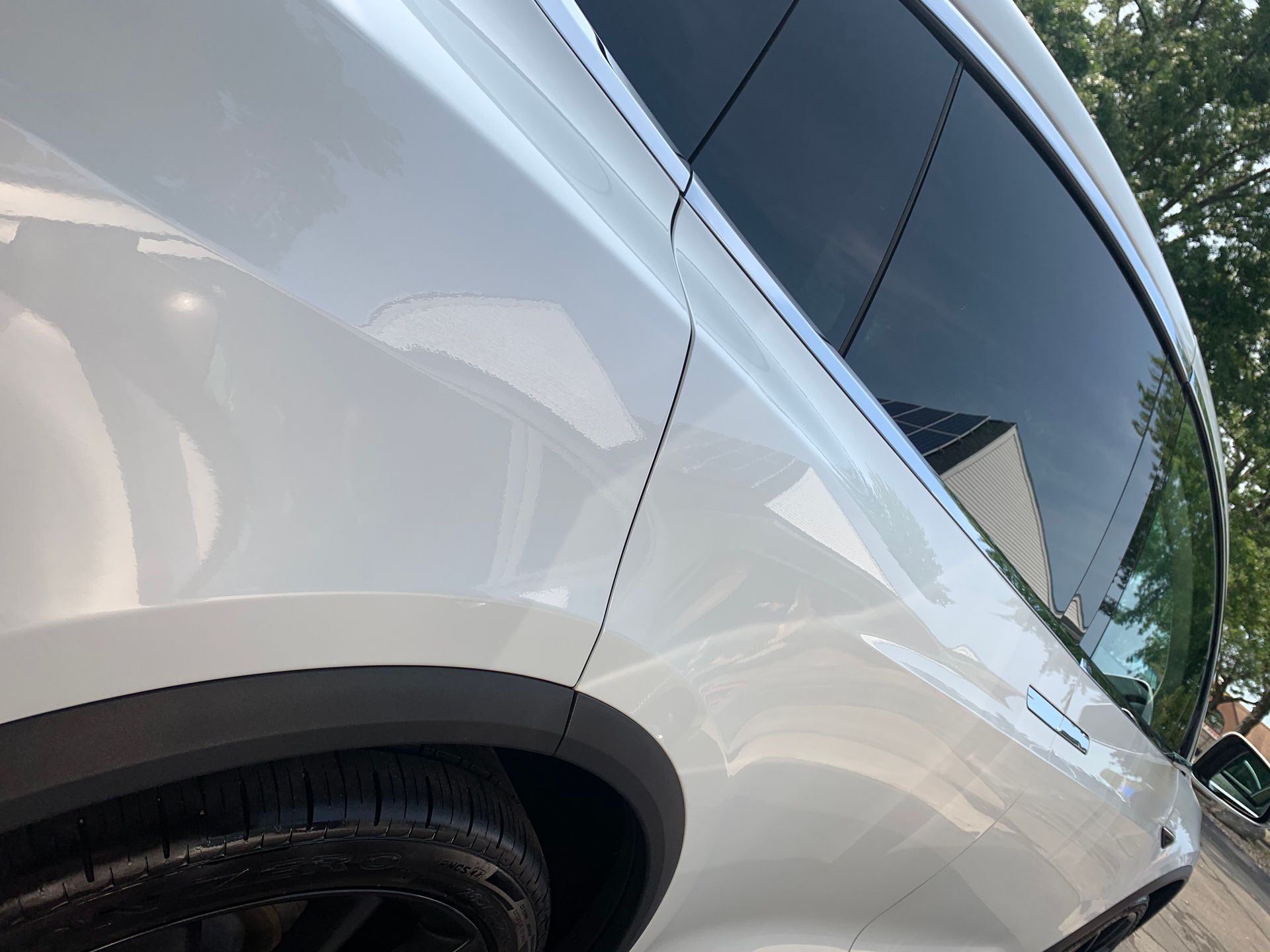 A white car is parked on the side of the road.