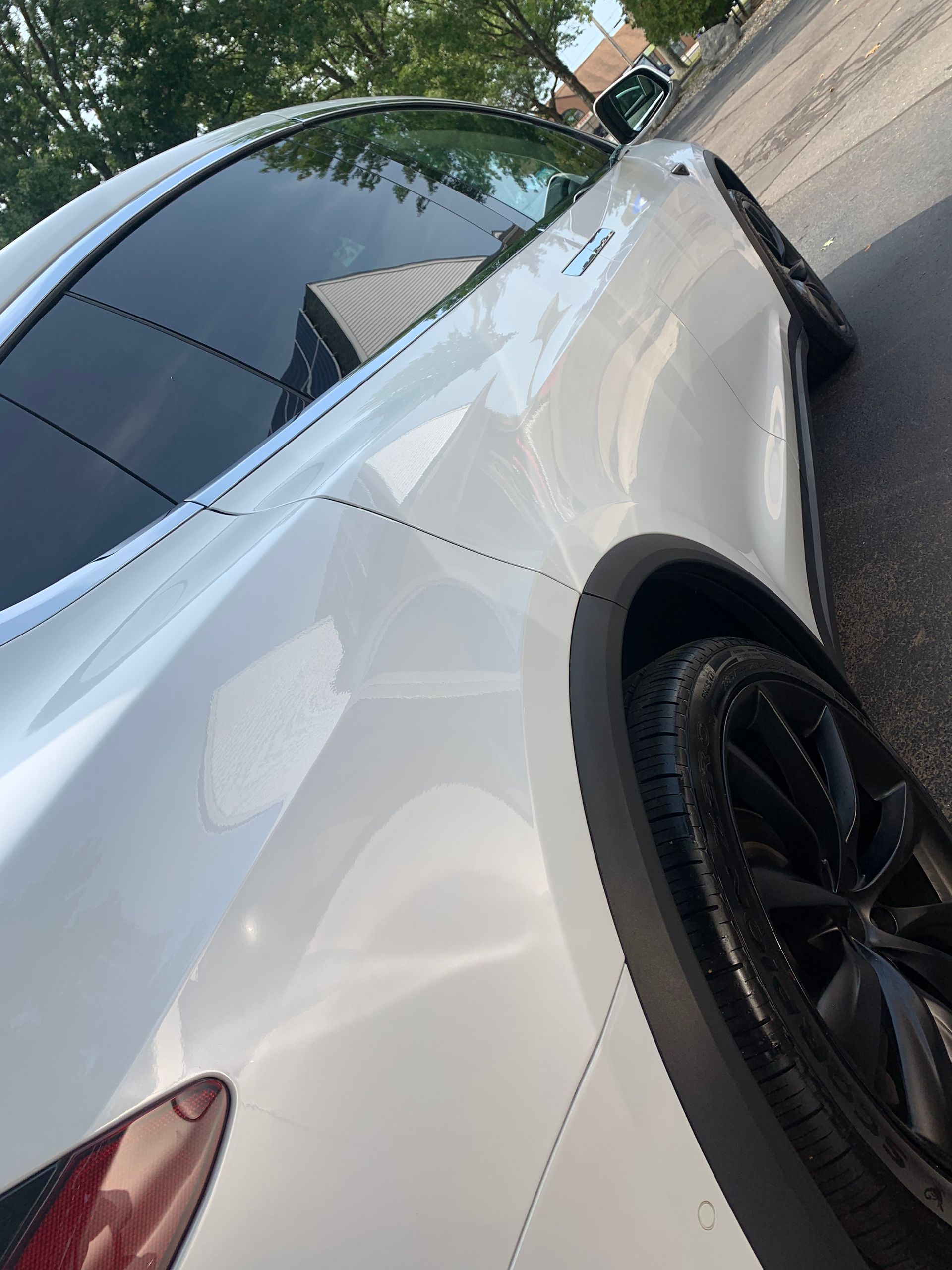 A white car is parked on the side of the road.