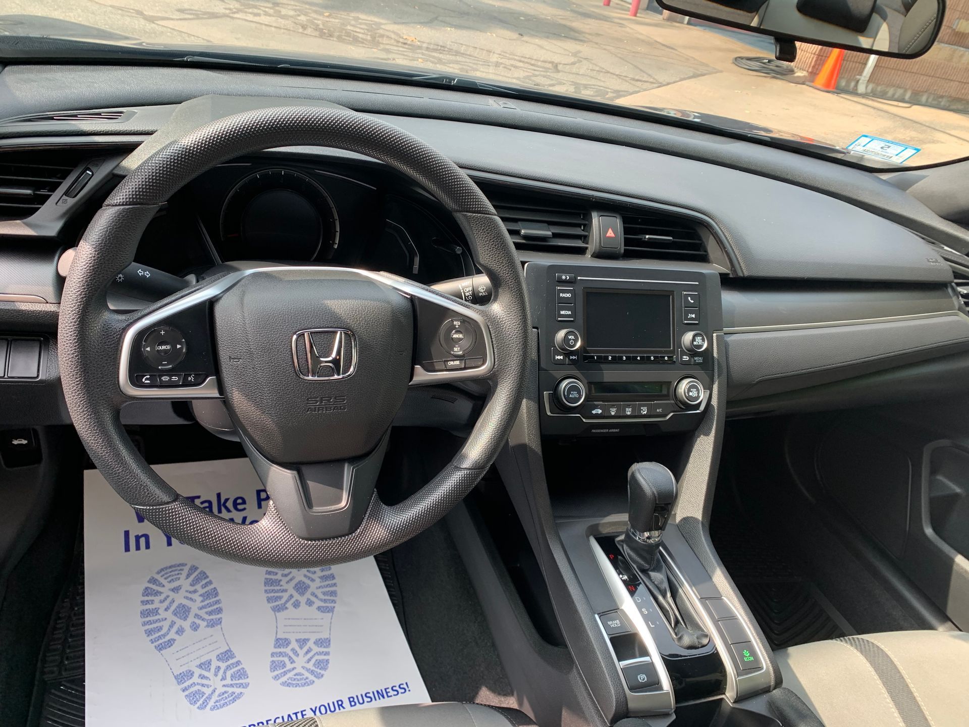 The interior of a honda civic with a steering wheel and dashboard.