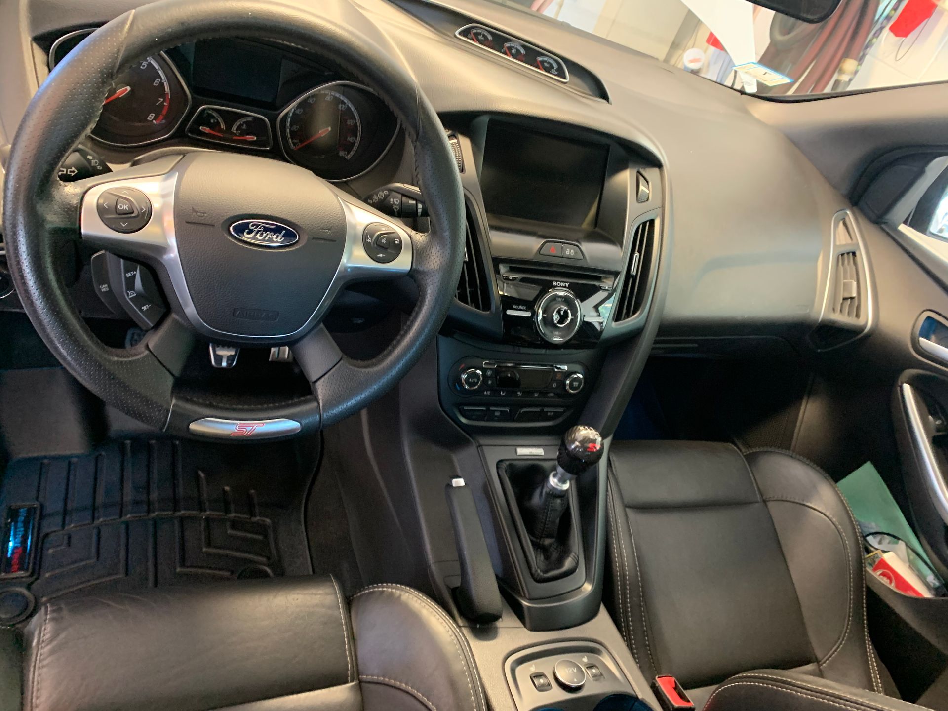 The interior of a ford focus with a steering wheel and dashboard.