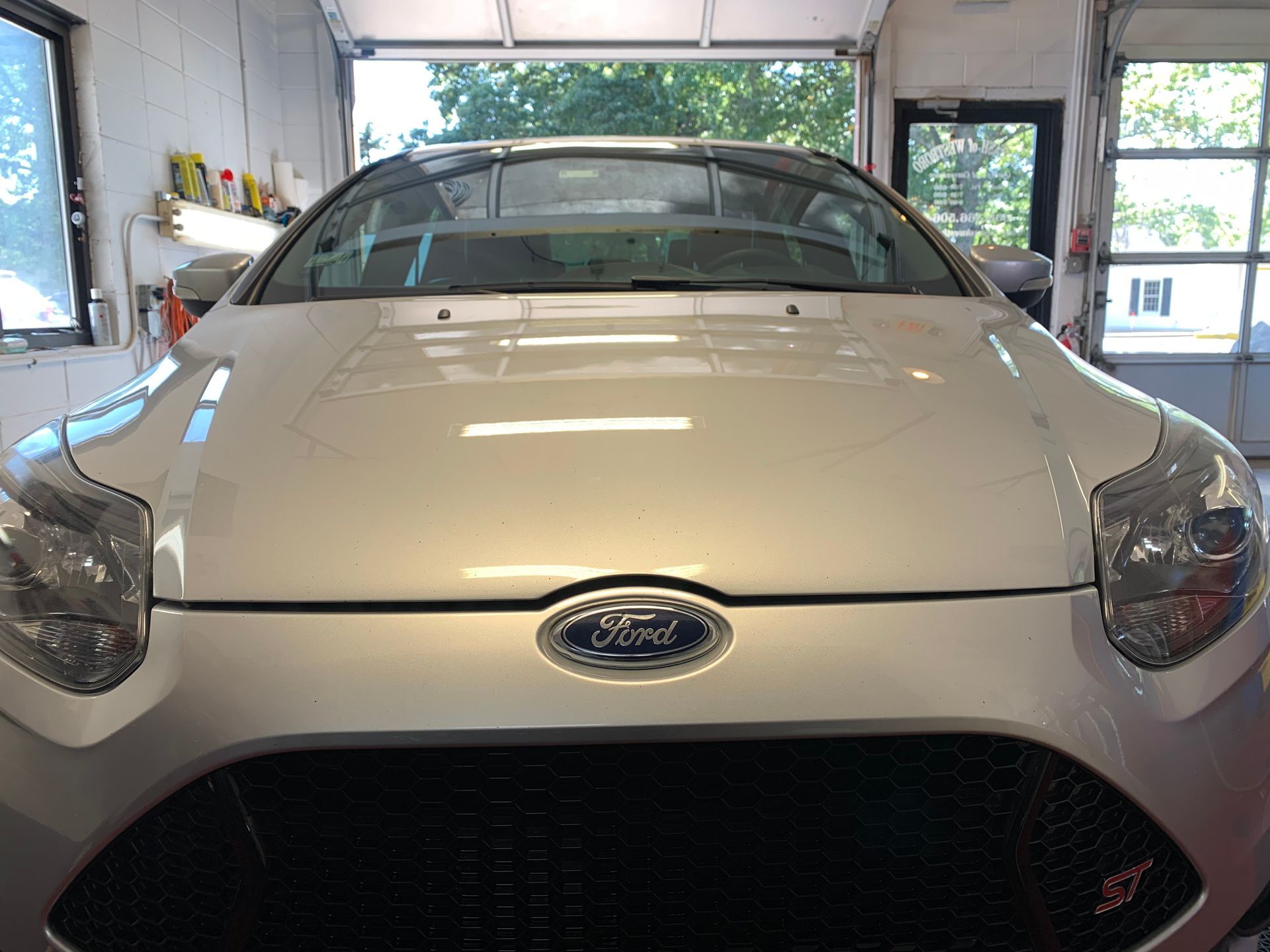 A silver ford car is parked in a garage.