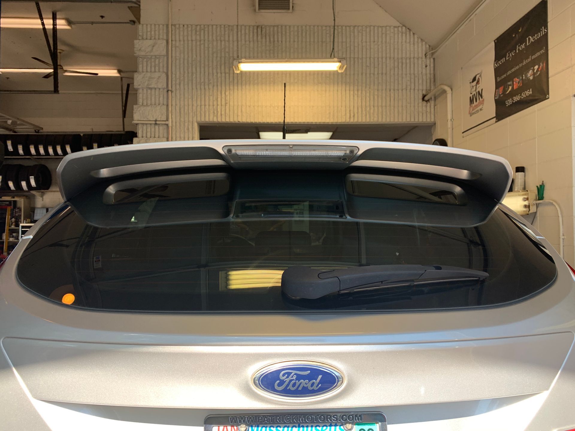 A silver ford car is parked in a garage.