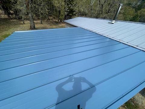 A blue roof with a shadow of a person on it