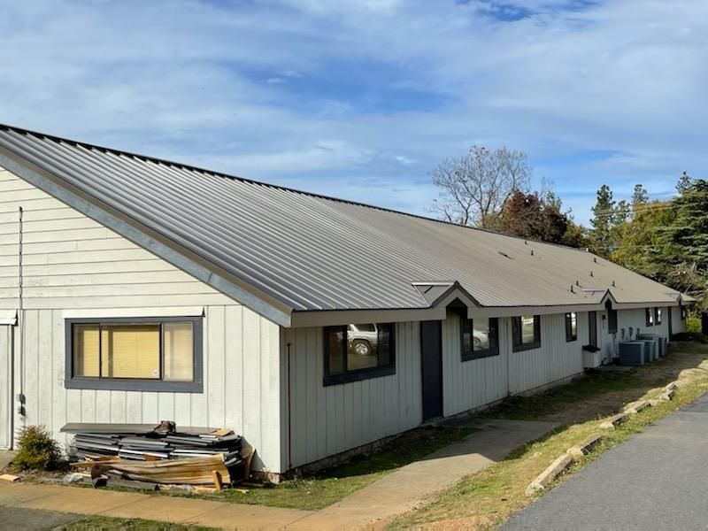 A row of white houses with a gray roof