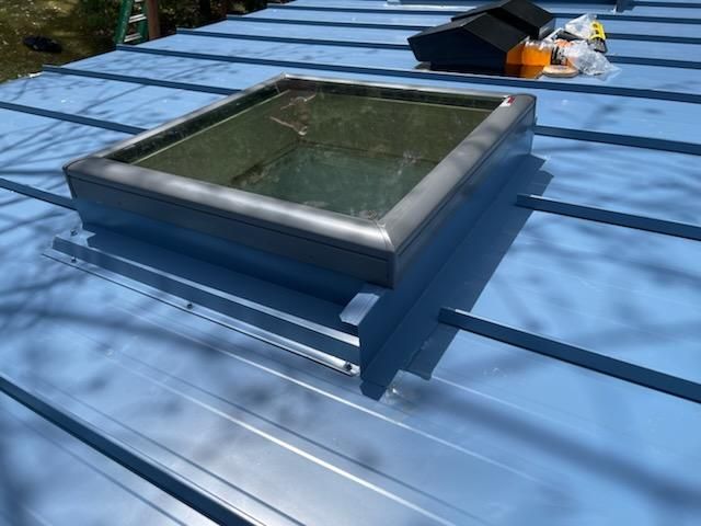 A skylight on top of a blue metal roof
