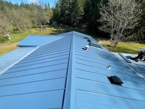 A man is working on the roof of a house.