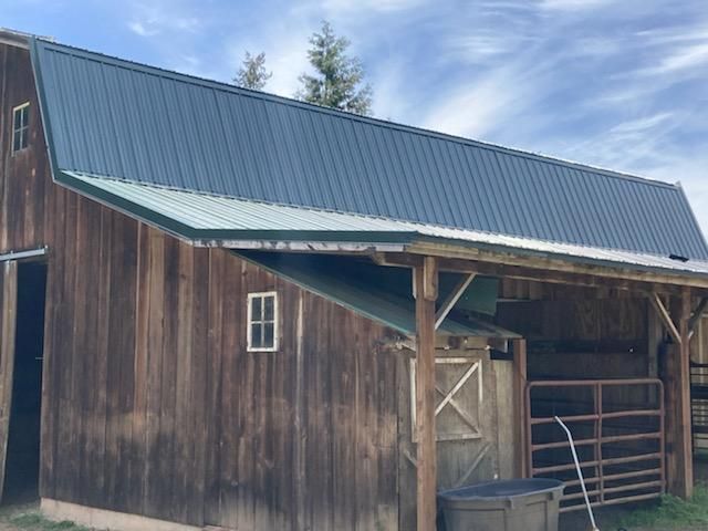 A wooden barn with a metal roof and a window