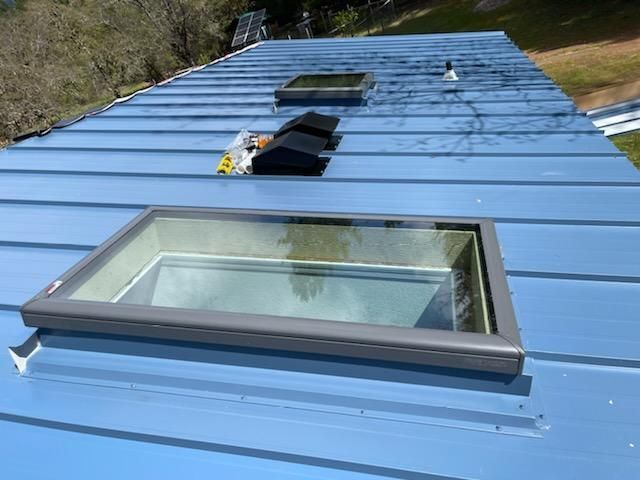 A blue roof with a skylight on it