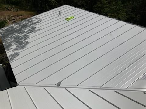 A close up of a white metal roof on a house.