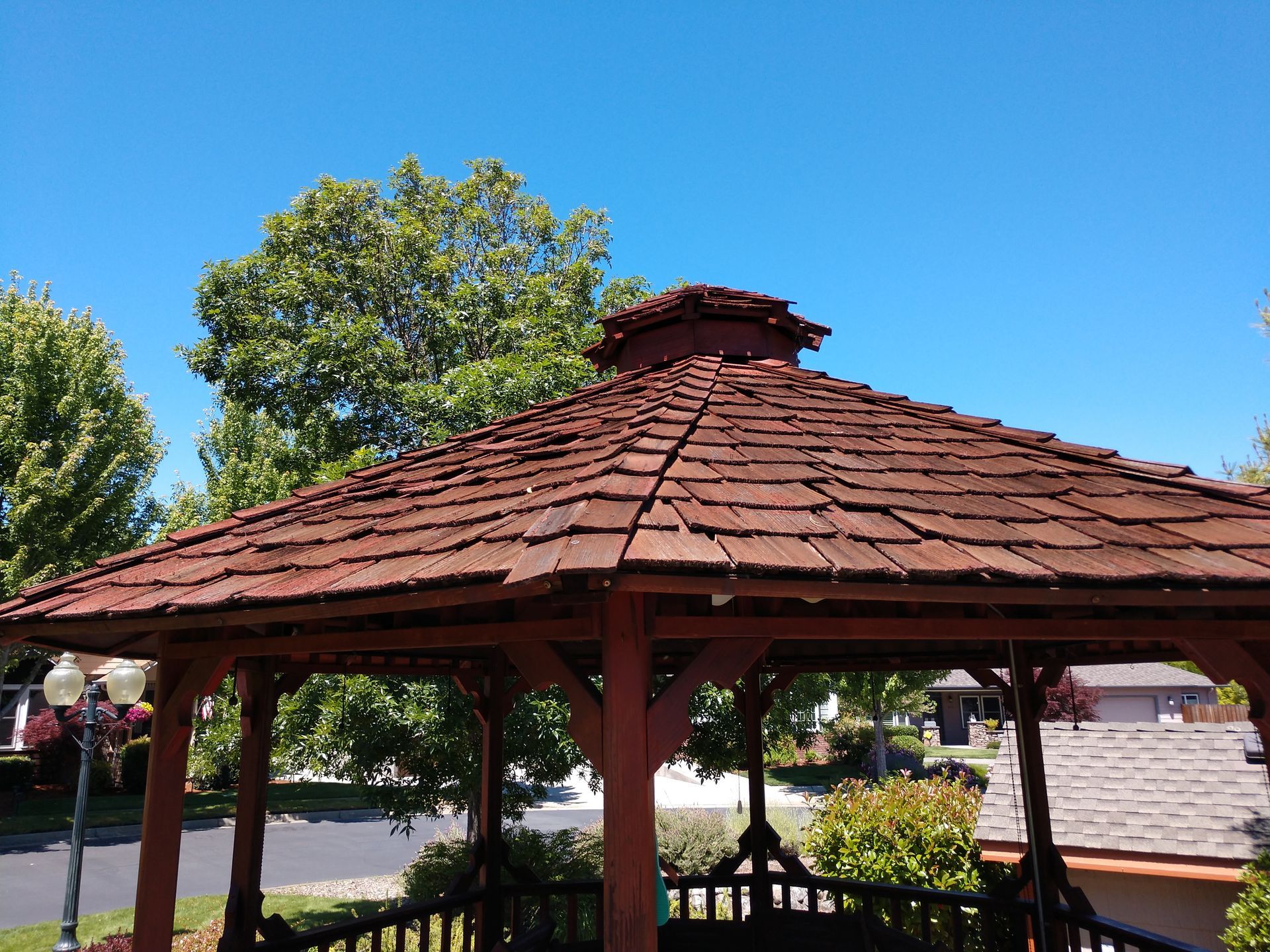 A gazebo with a wooden roof and a blue sky in the background