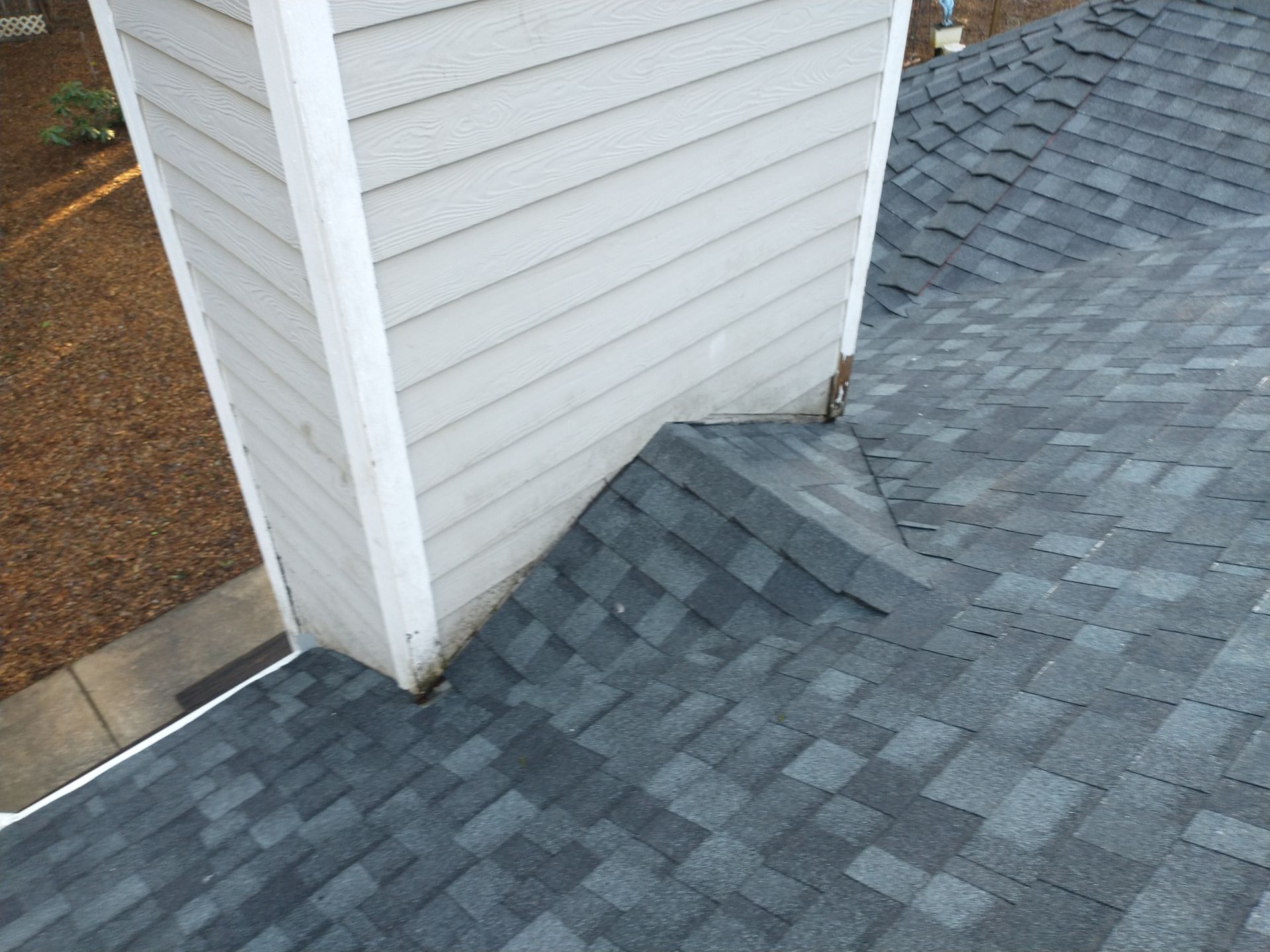 A roof with a chimney on the side of it