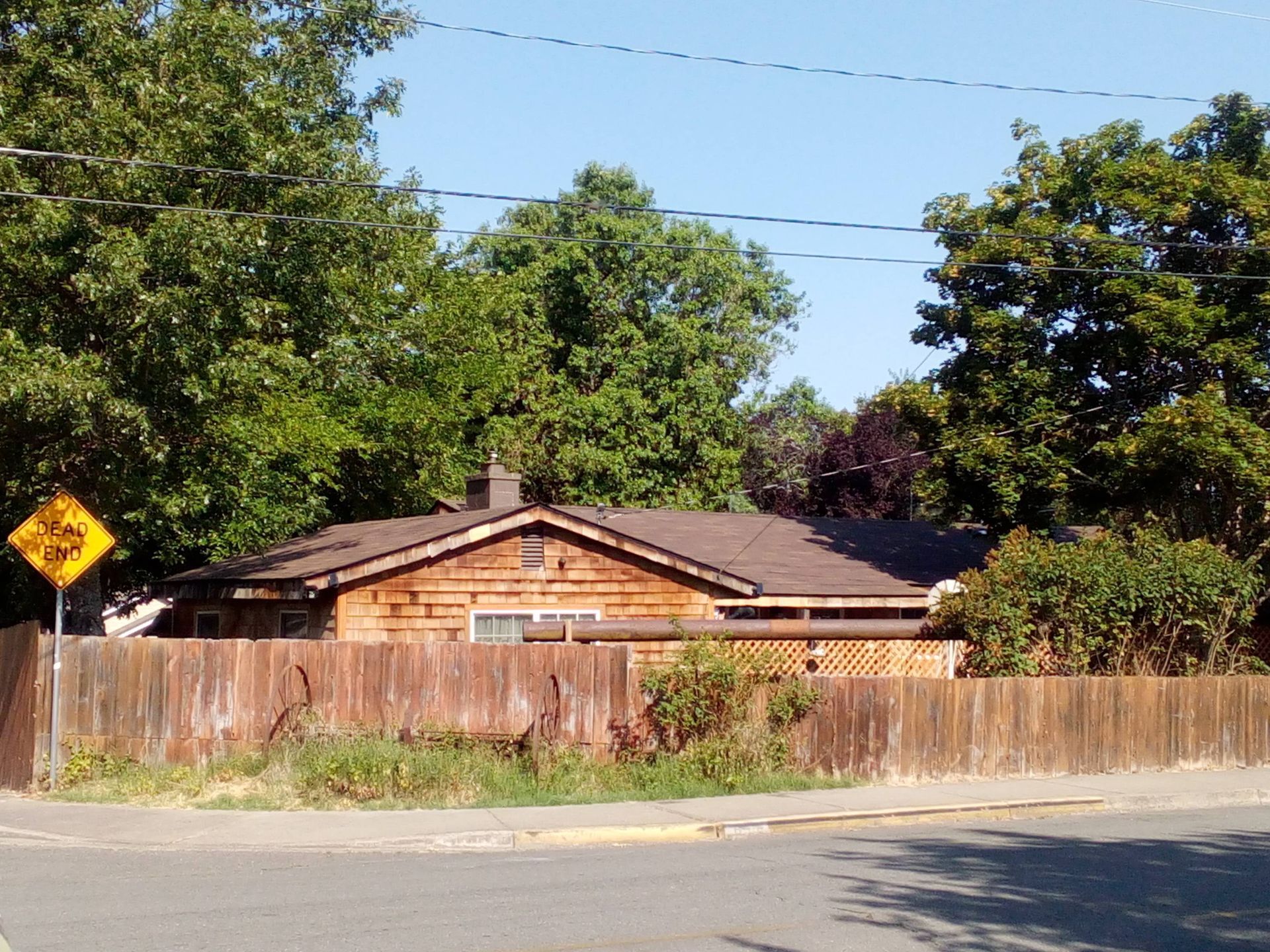 A house with a wooden fence and a yellow sign that says no parking