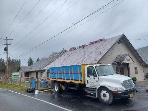 A dump truck is parked in front of a house.