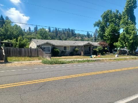 A house sits on the side of a road next to a fence