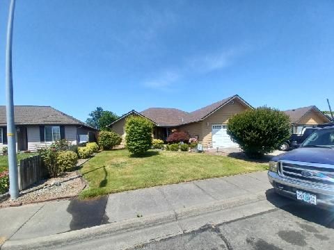A blue truck is parked in front of a house.