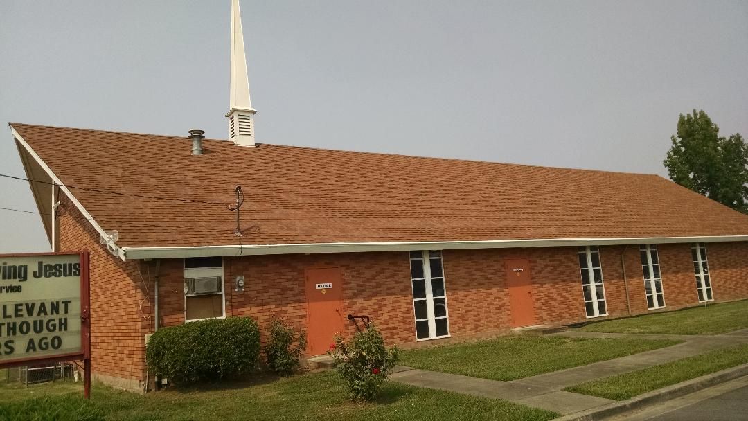 A church with a steeple and a sign that says 