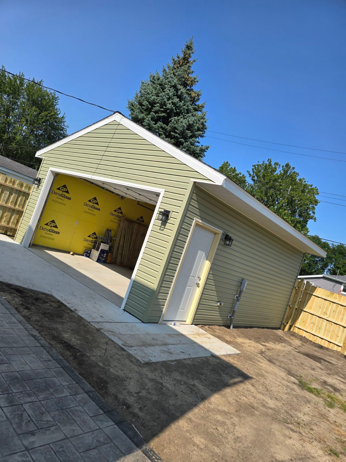 A garage is being built in the backyard of a house.