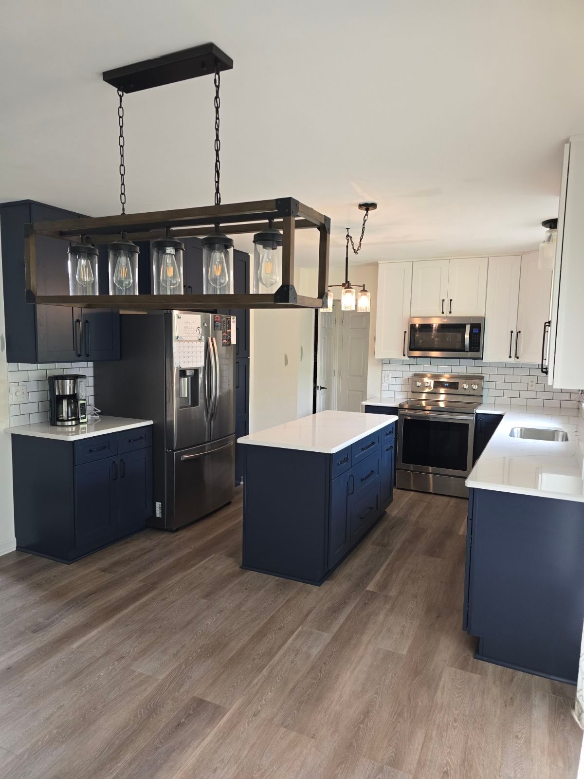 A kitchen with blue cabinets and white counter tops
