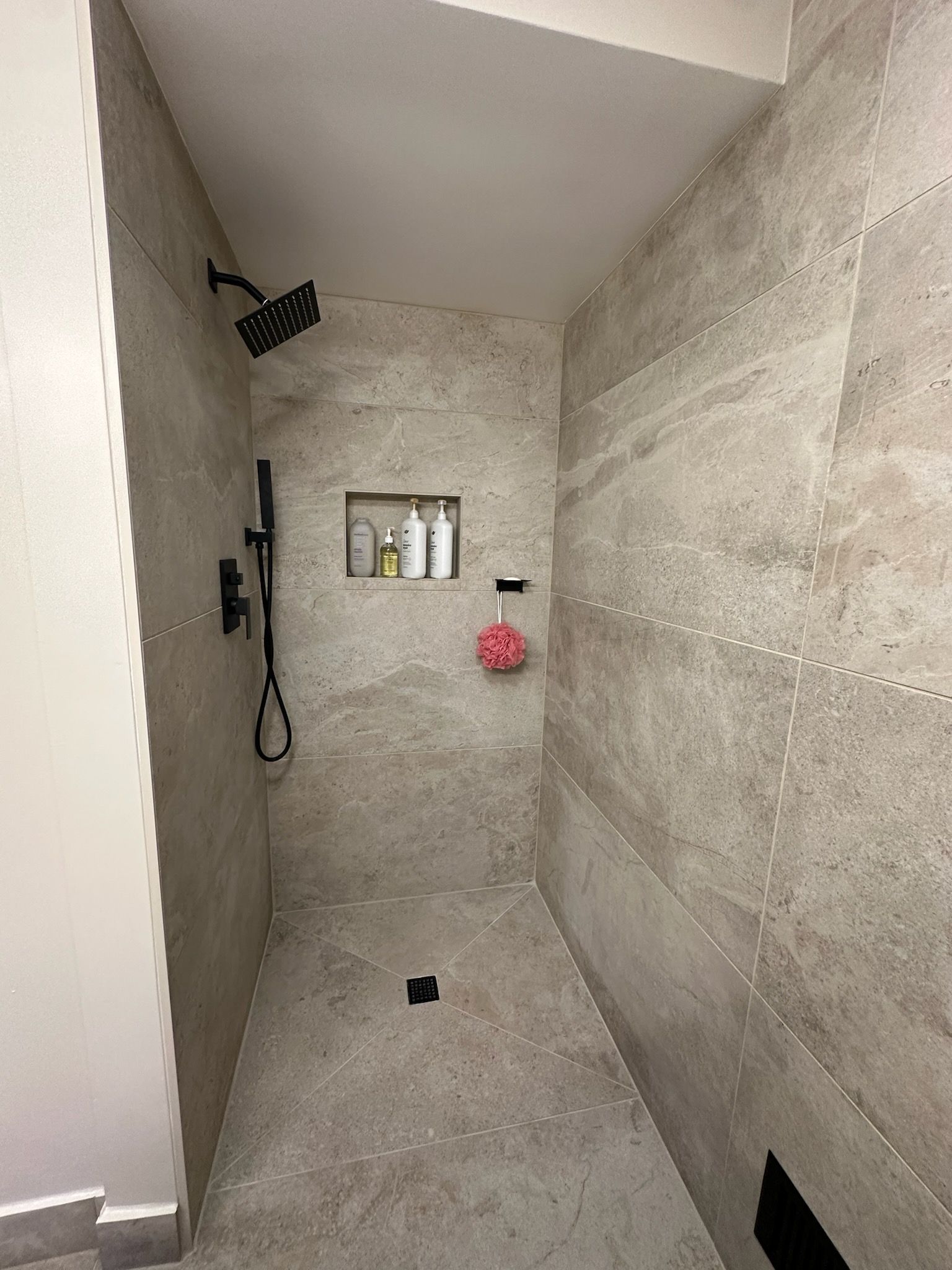 A full tile bathroom with a walk in shower.