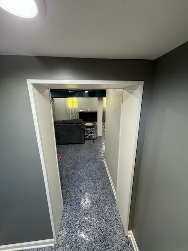 A hallway leading to a living room in a house.