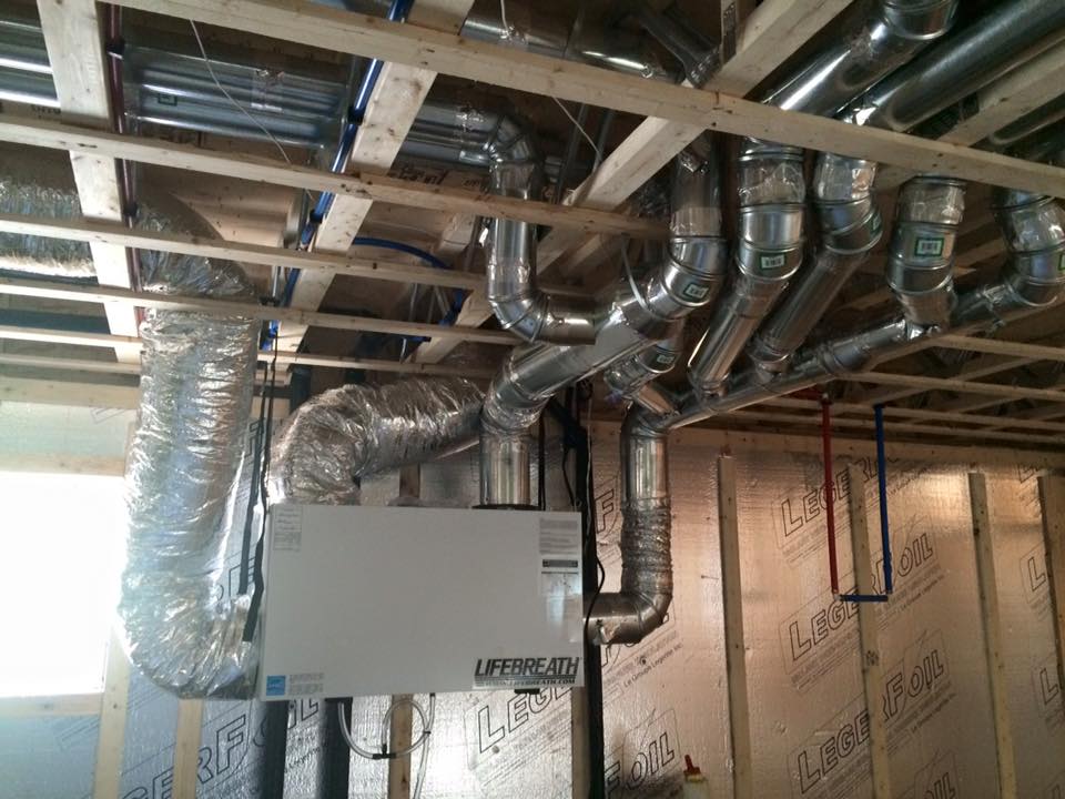 Un tas de tuyaux sont suspendus au plafond d’un immeuble.