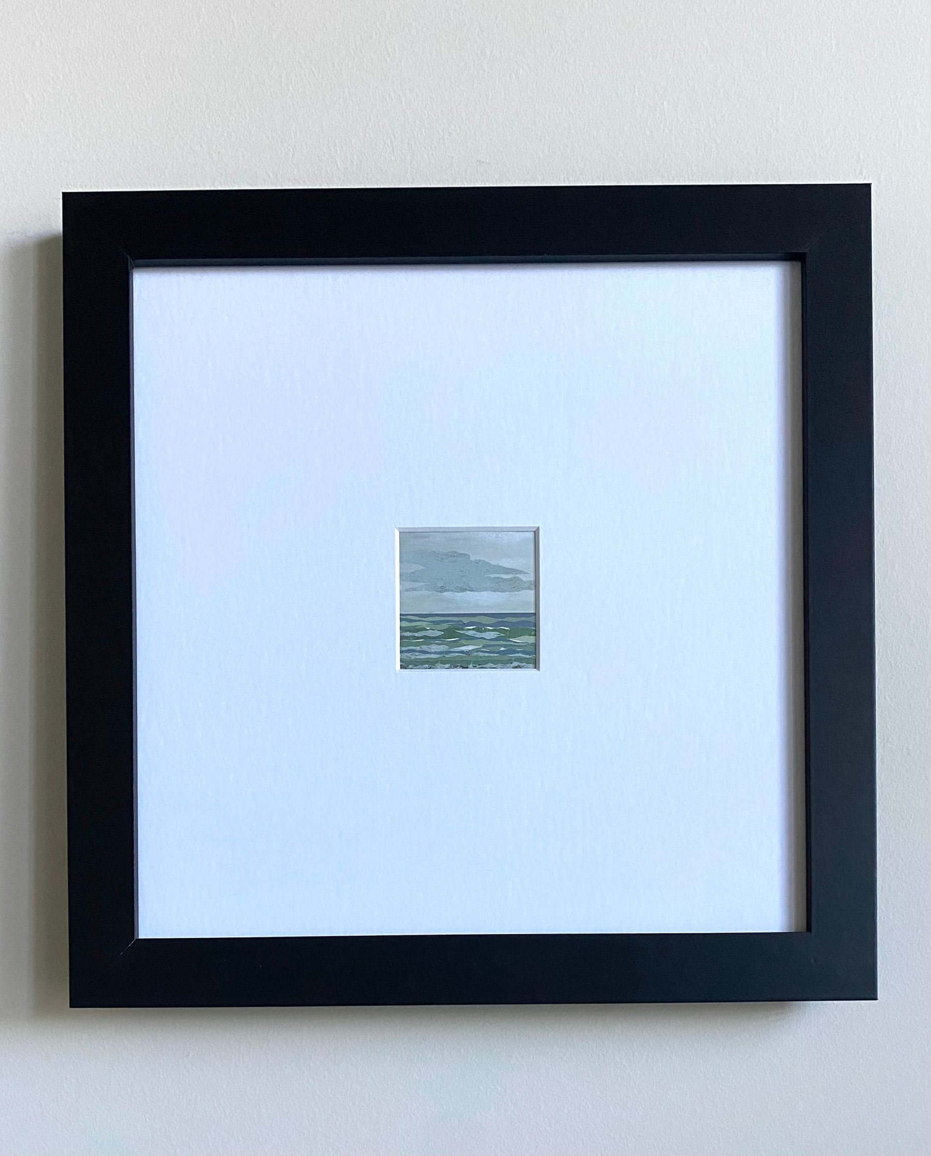 Sea scene with green and blue waves under a cloudy sky.