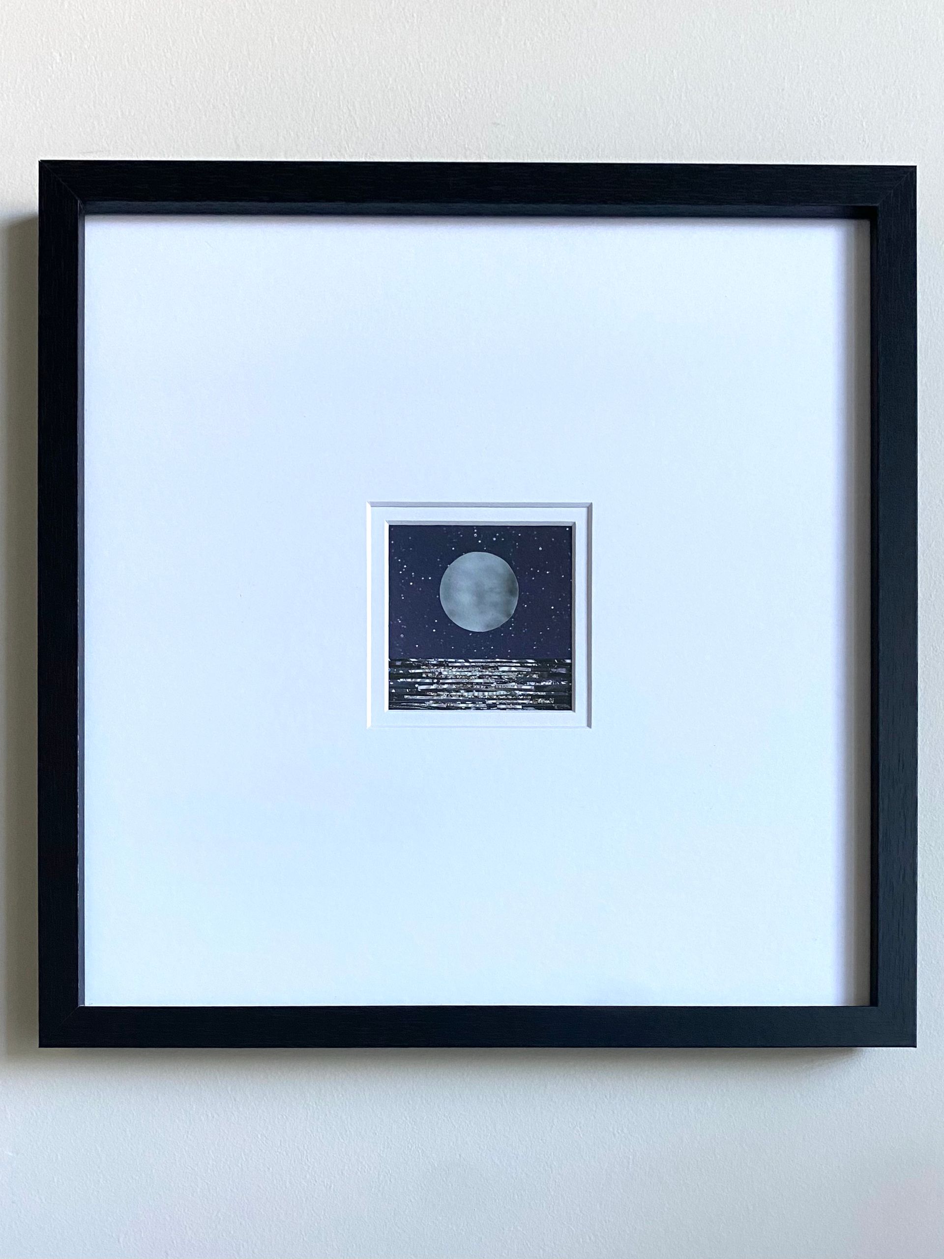 Full moon over shimmering water with stars in the night sky.