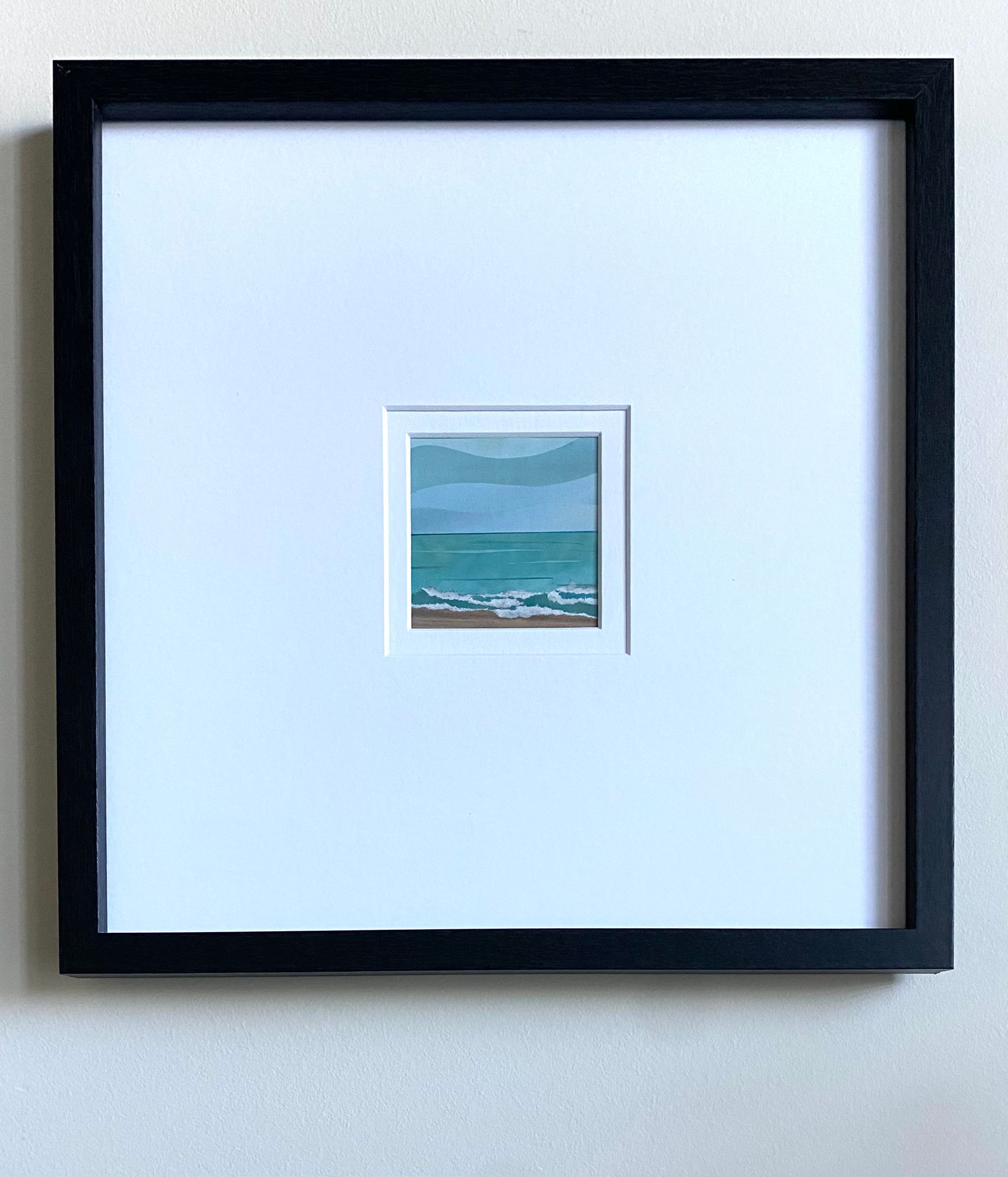 Beach scene with turquoise water, foamy waves, tan sand, and layered blue sky.