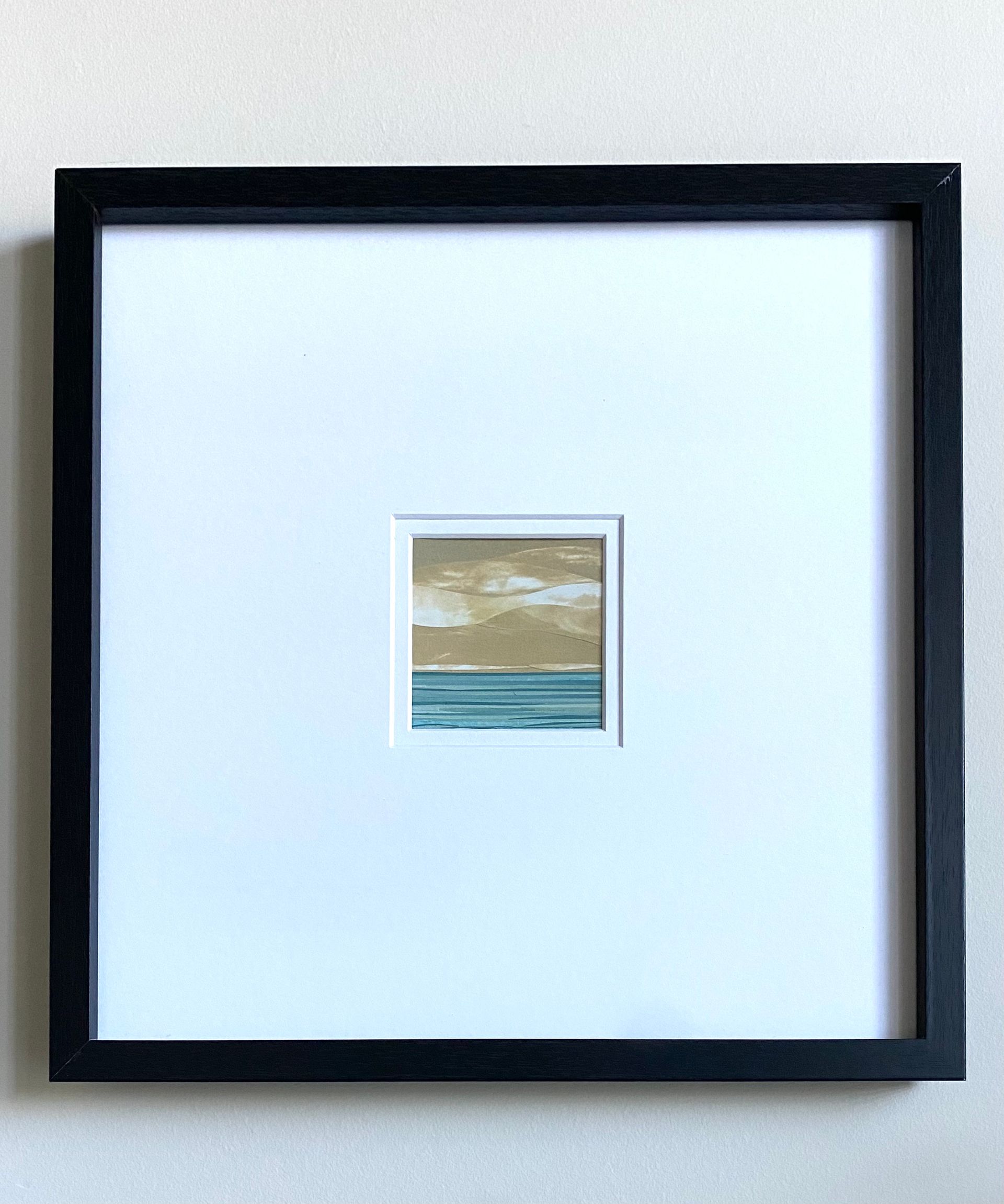 Rolling tan hills above teal water.