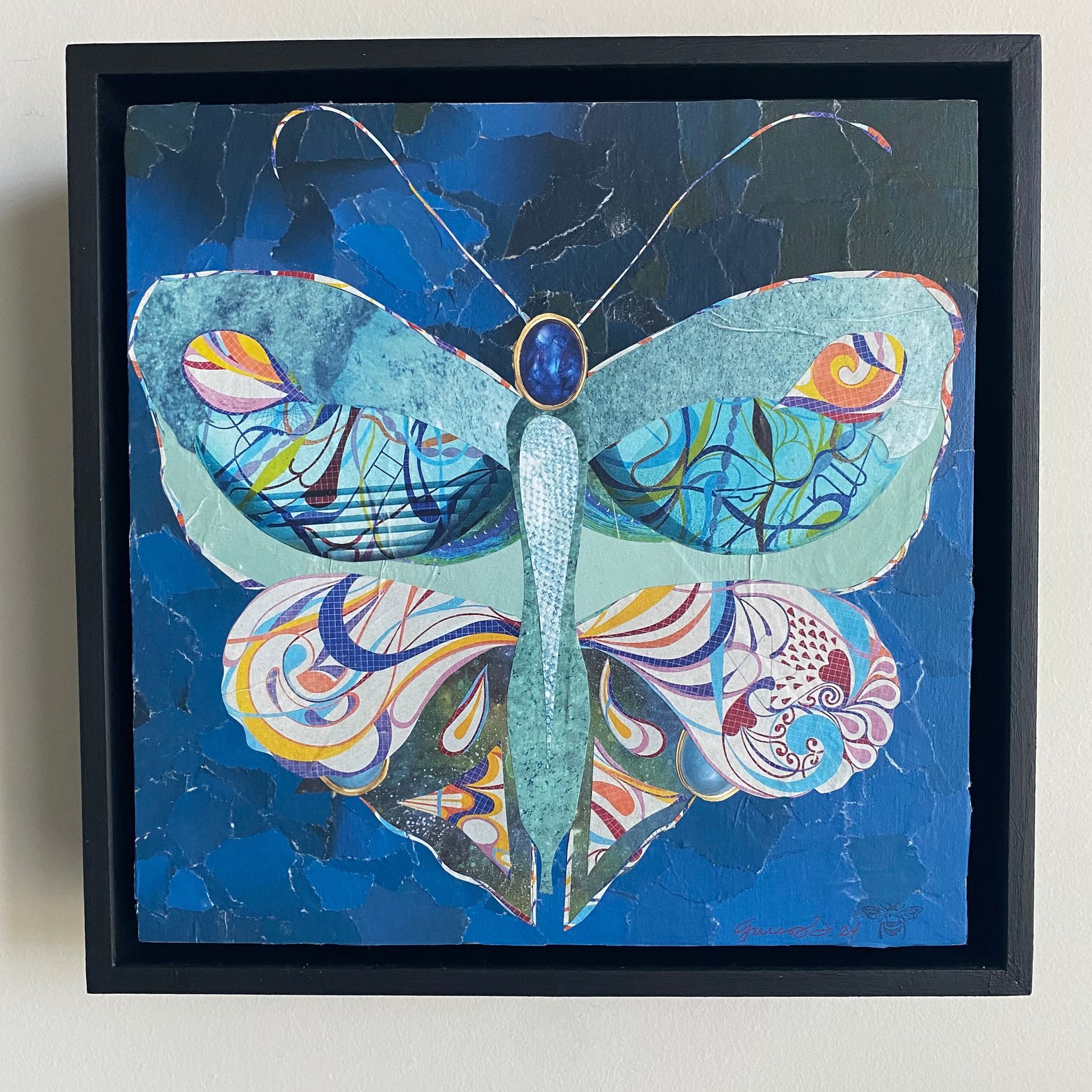 Butterfly collage, blue hues, with ornate wing patterns, against a textured blue background.