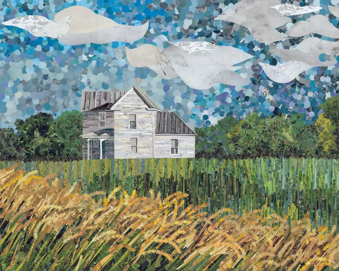 Abandoned house in a field under a cloudy blue sky. Wheat in the foreground, trees in the background.