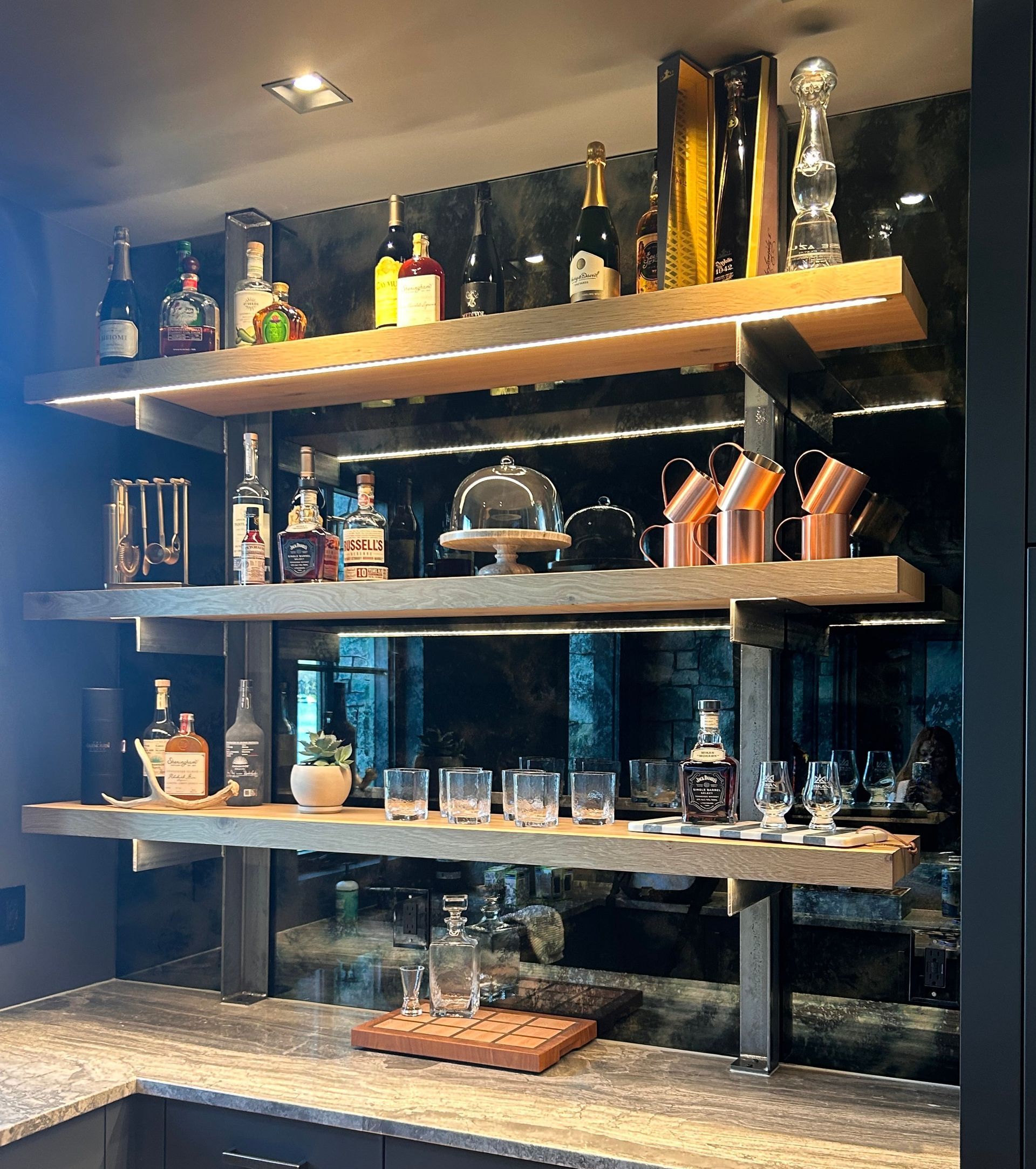 A bar with shelves filled with bottles and glasses