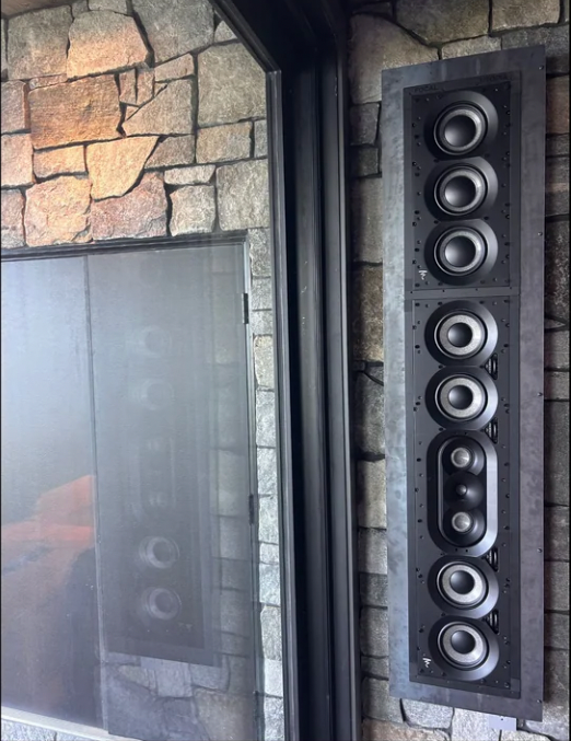 A row of speakers mounted to a stone wall