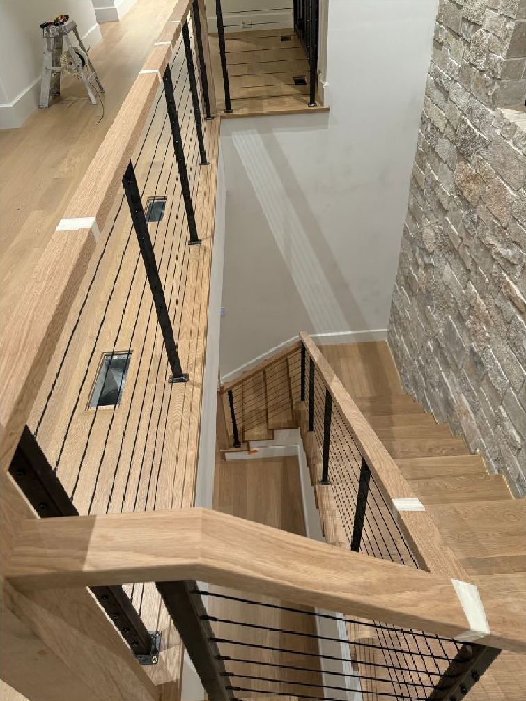 An aerial view of a wooden staircase with a metal railing.