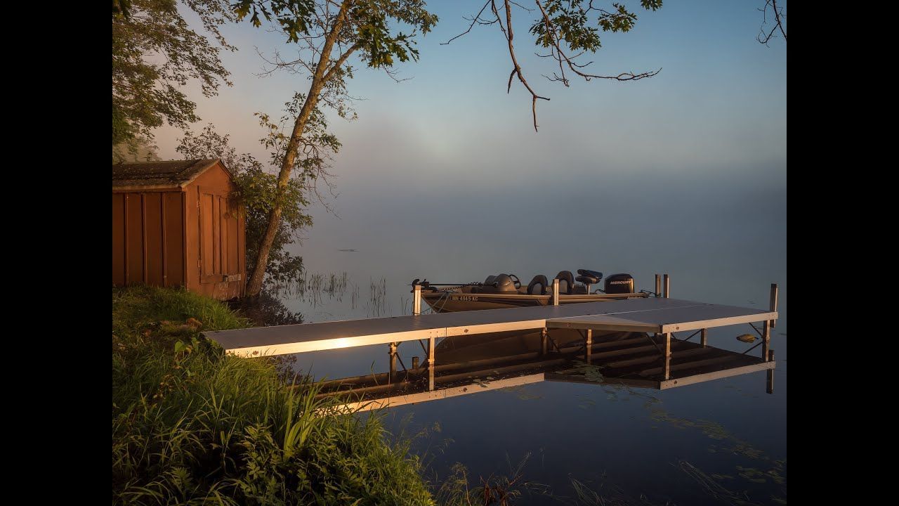 A boat is docked at a dock on a lake.
