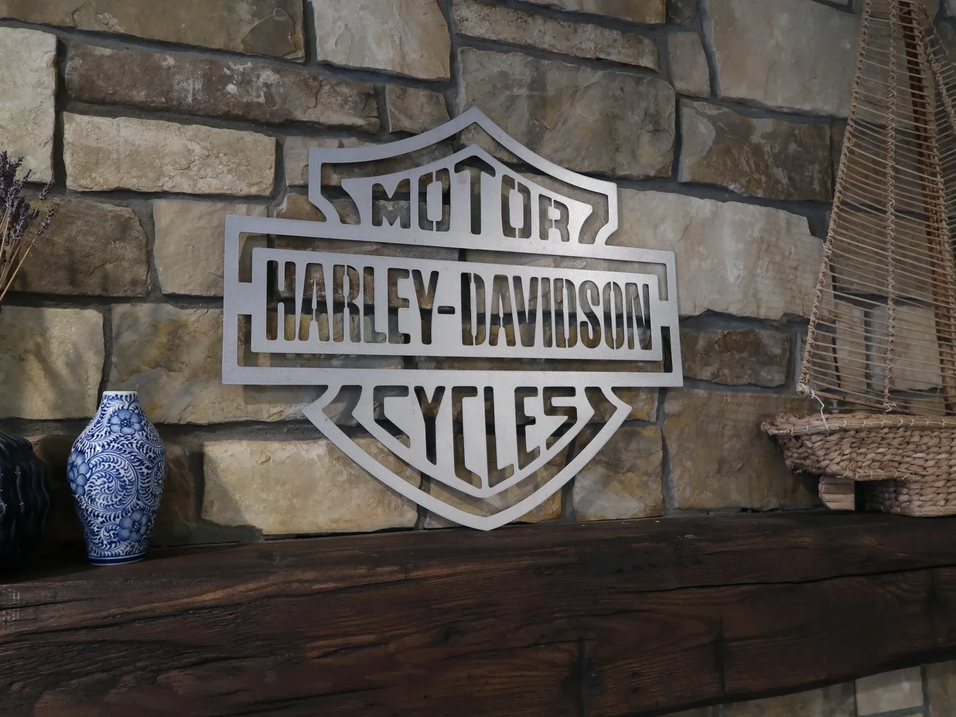A harley davidson sign is hanging on a brick wall.