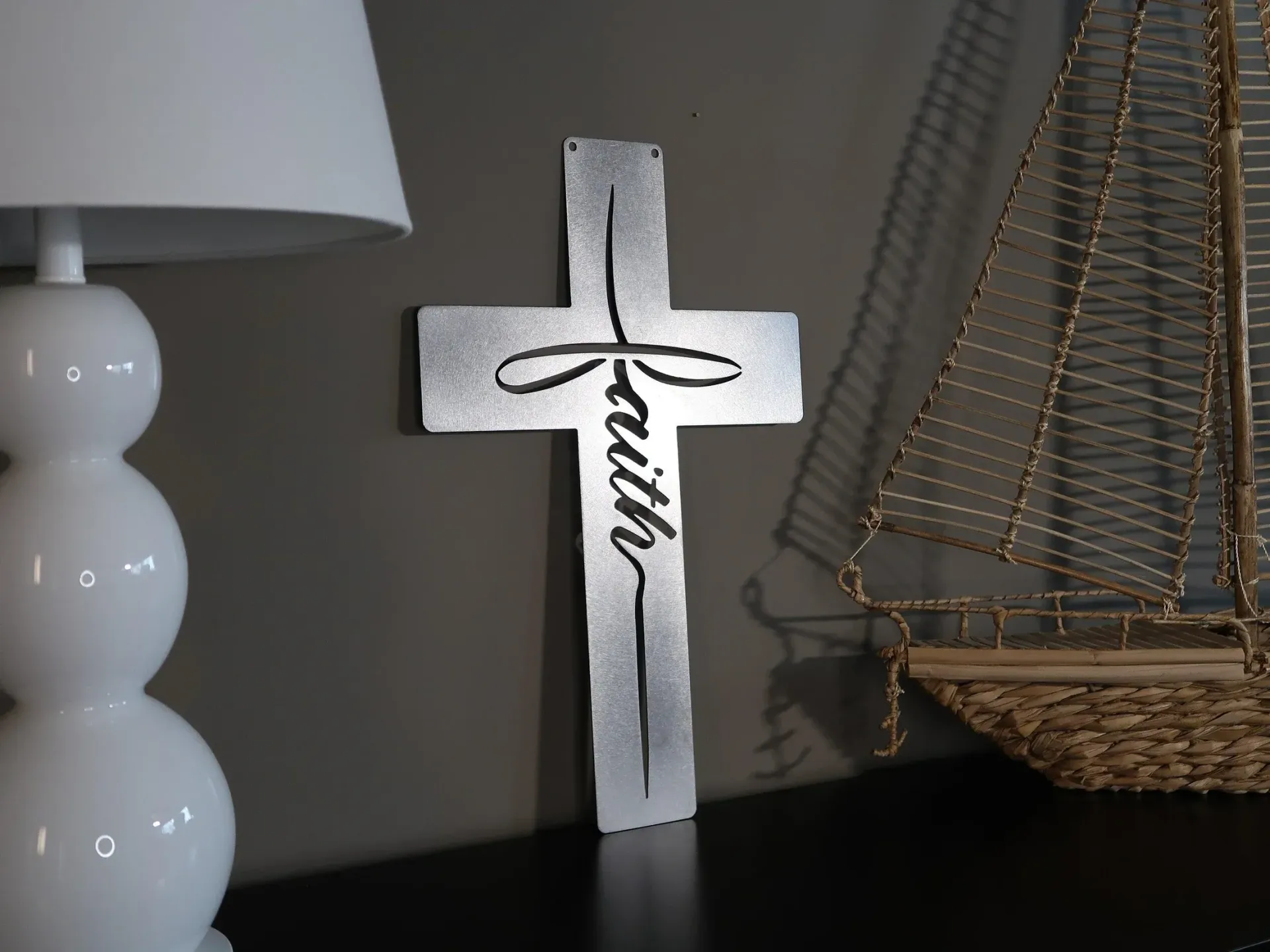 A silver cross with the word faith on it