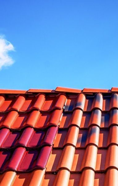 A red tiled roof with a blue sky in the background