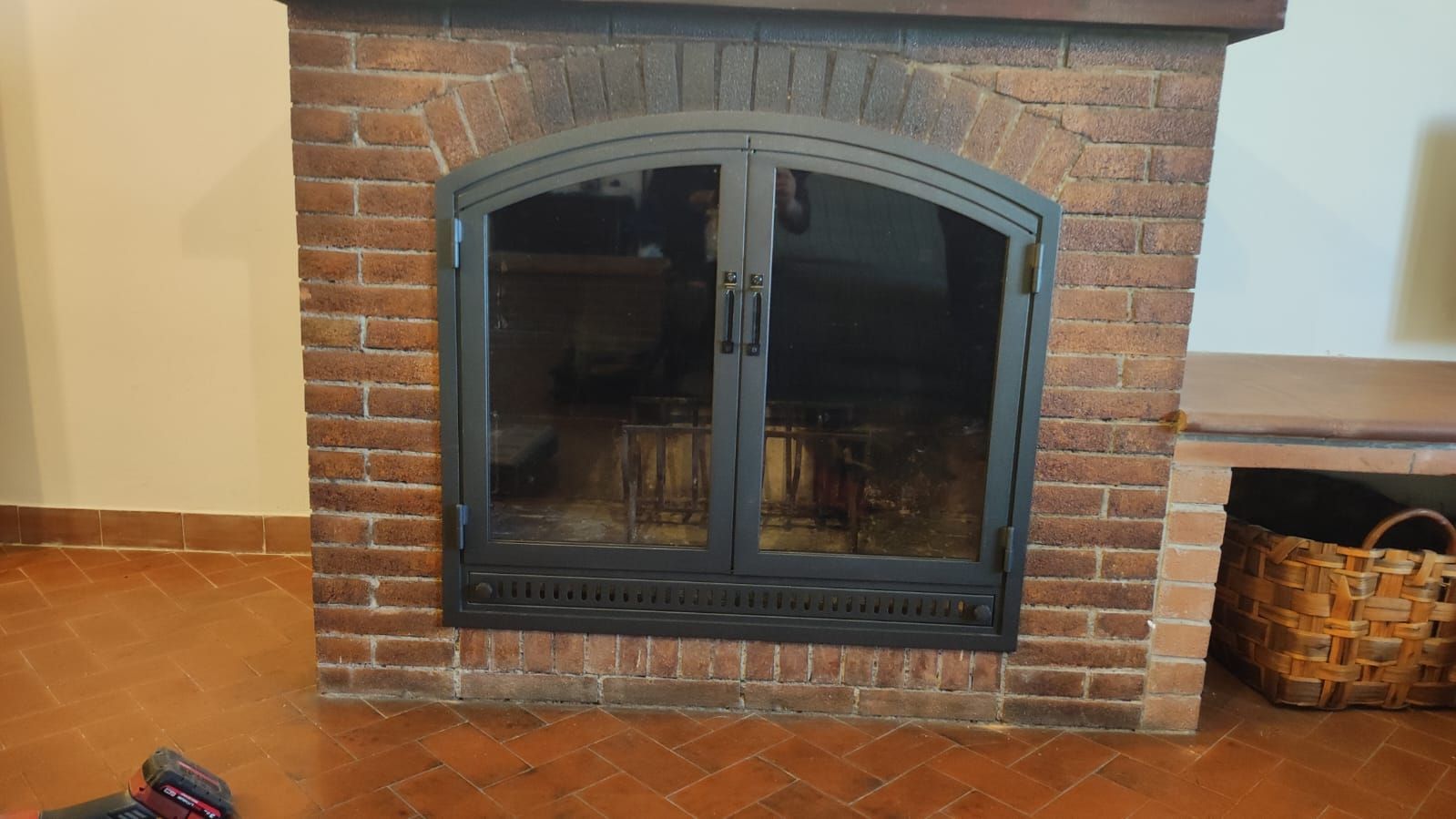 Un camino in mattoni con una porta a vetri in un soggiorno.