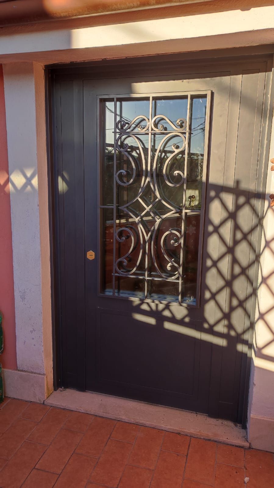 Una porta nera con un motivo in ferro battuto