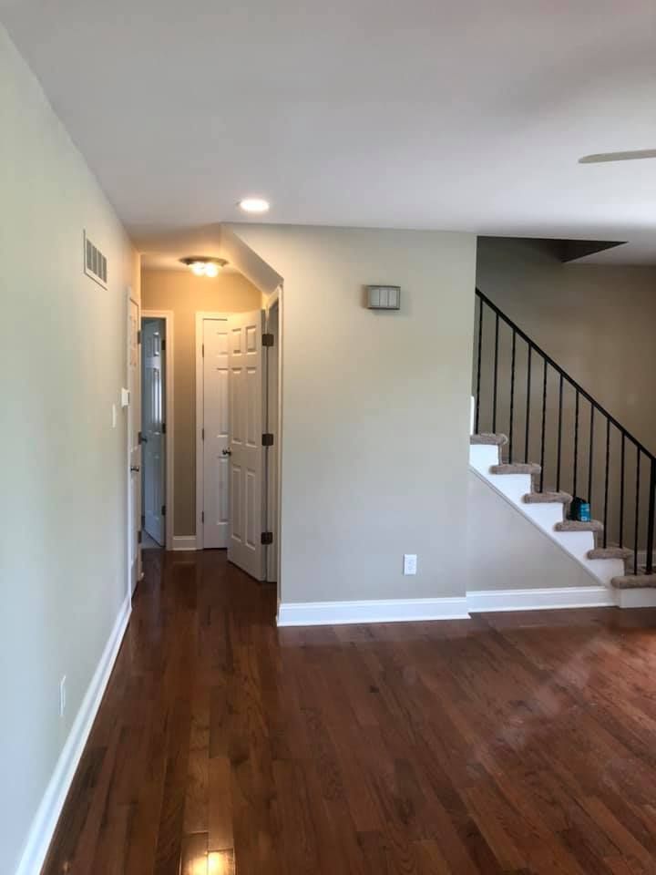 Wooden deck with pergola attached to a house with stairs.