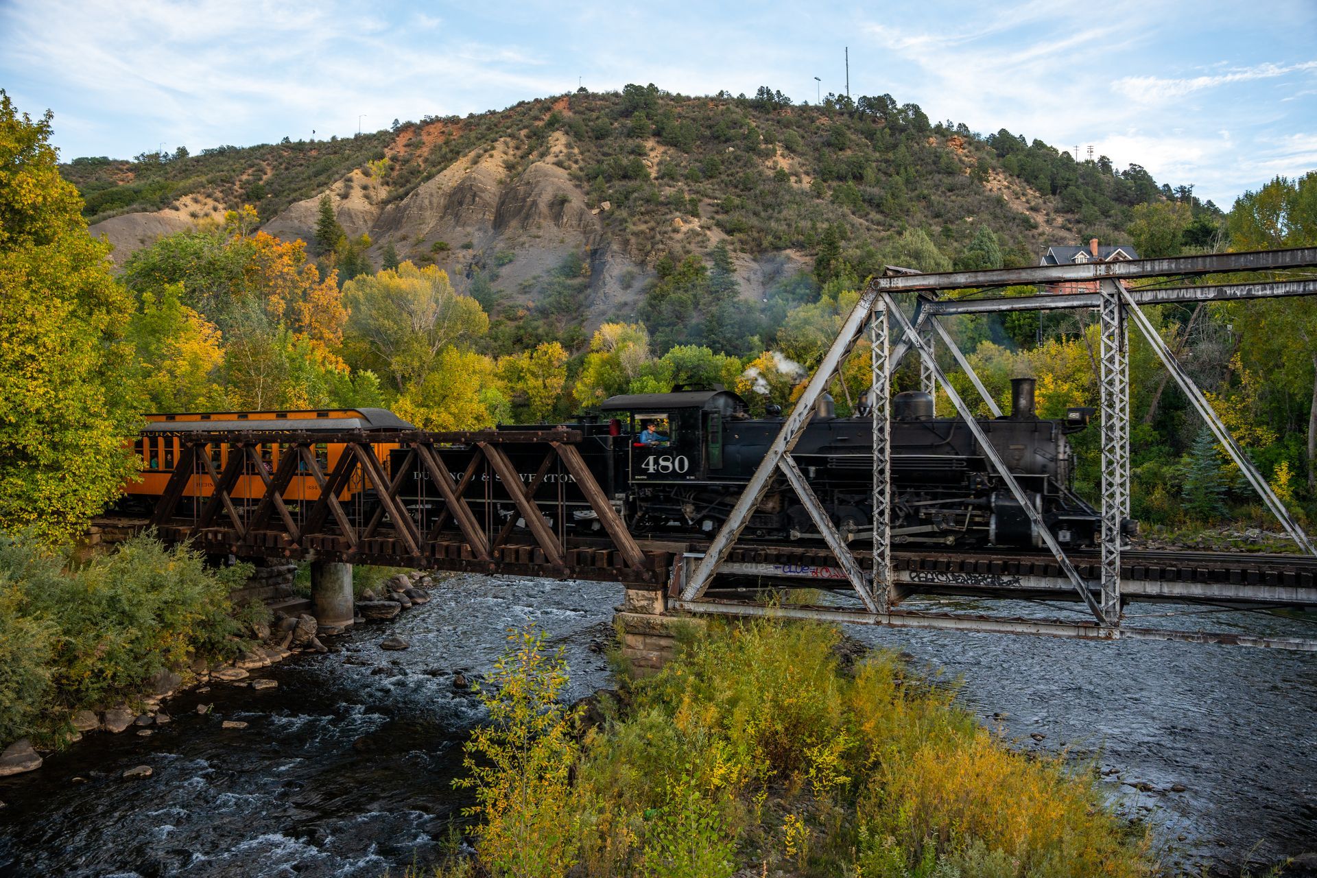 A train is going over a bridge over a river.