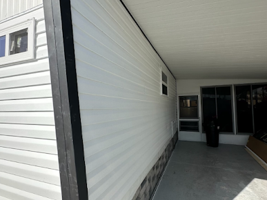 White siding and dark trim on a building with a covered walkway.