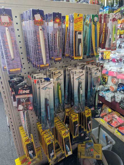 Fishing lures for sale, arranged on a store display. Many different brands and colors are visible.