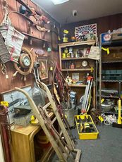 Antique store interior filled with various items, including clocks, tools, and signs.