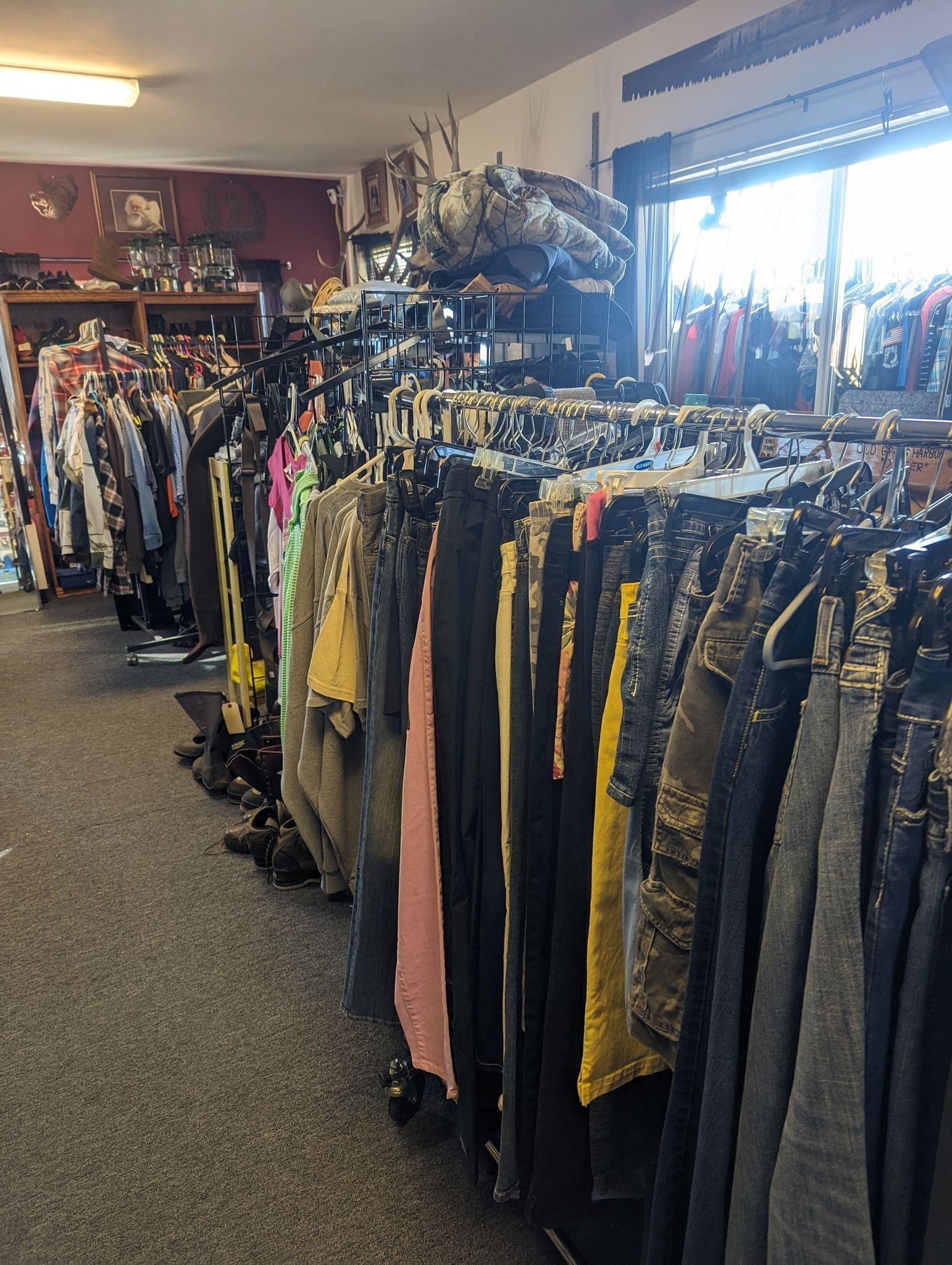 Clothes racks in a shop. Various clothing items in different colors hang on racks.