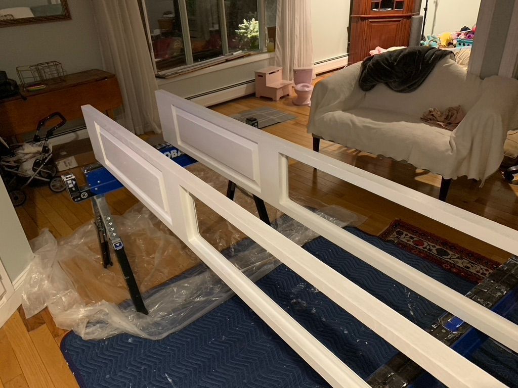 Two white wood frames on sawhorses, interior setting.