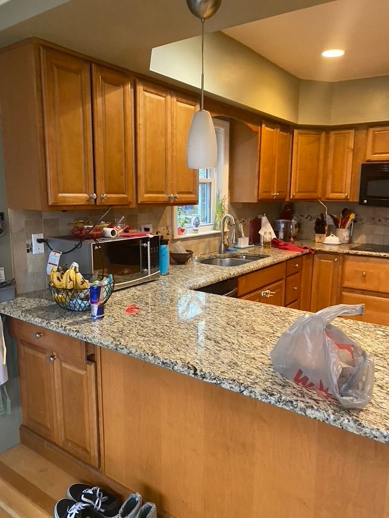 Kitchen with light wood cabinets, granite countertops, and stainless steel appliances.